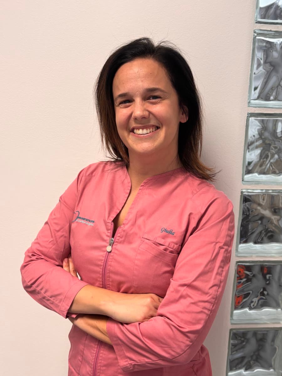 Ritratto di Giulia, assistente, con la divisa rosa degli studi, a braccia conserte
