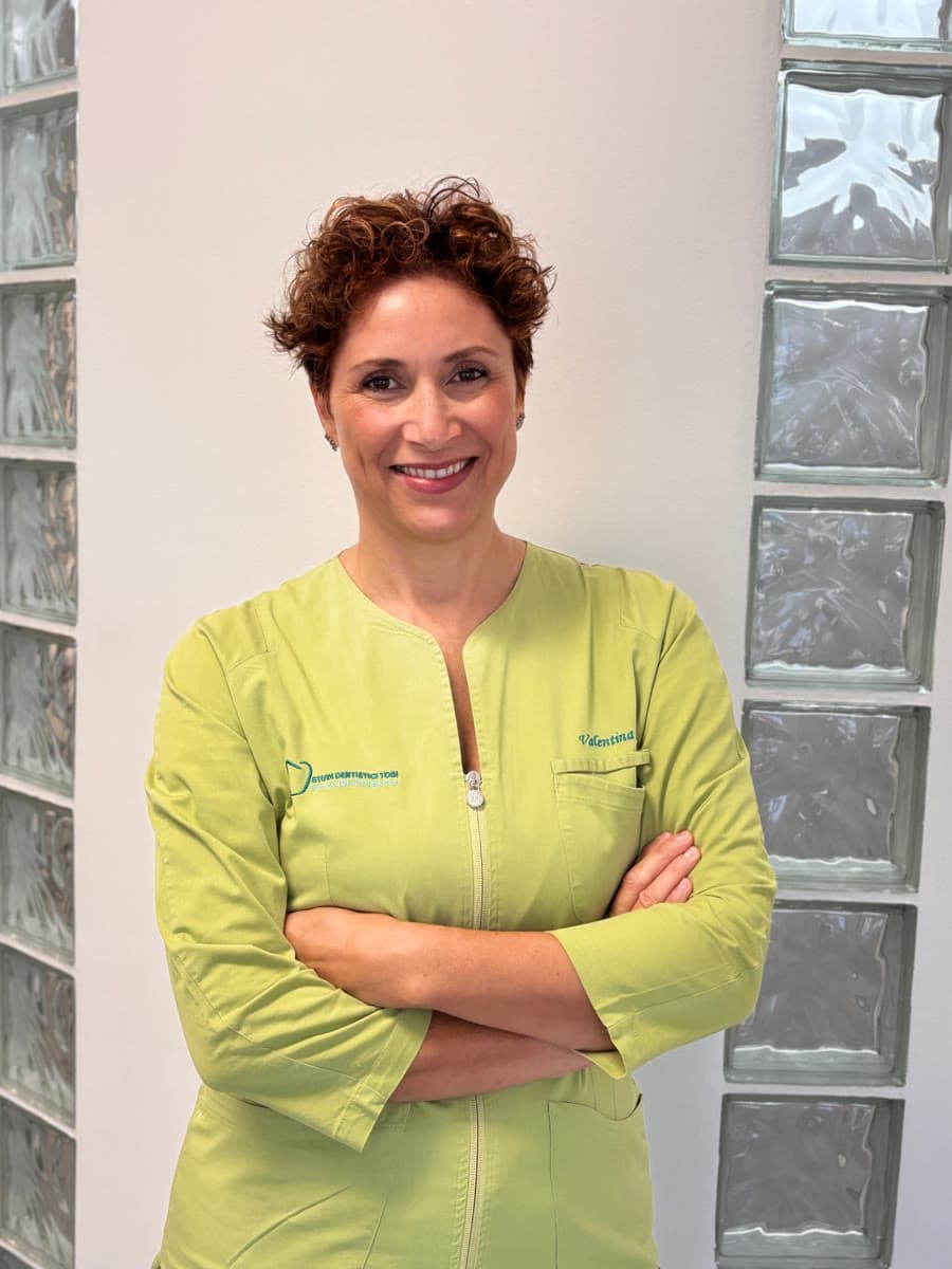 Ritratto di Valentina, assistente, con la divisa verde degli studi, a braccia conserte